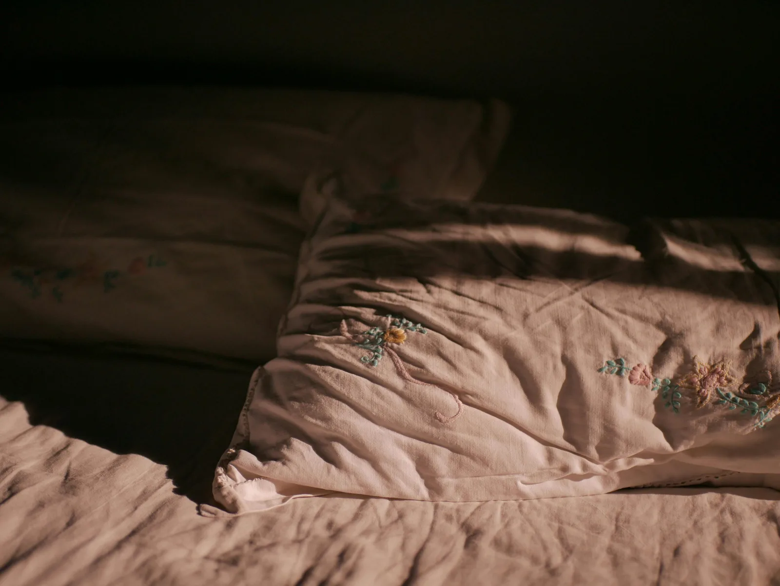 Linge de lit brodé en lin naturel avec motifs floraux — atmosphère romantique et douce