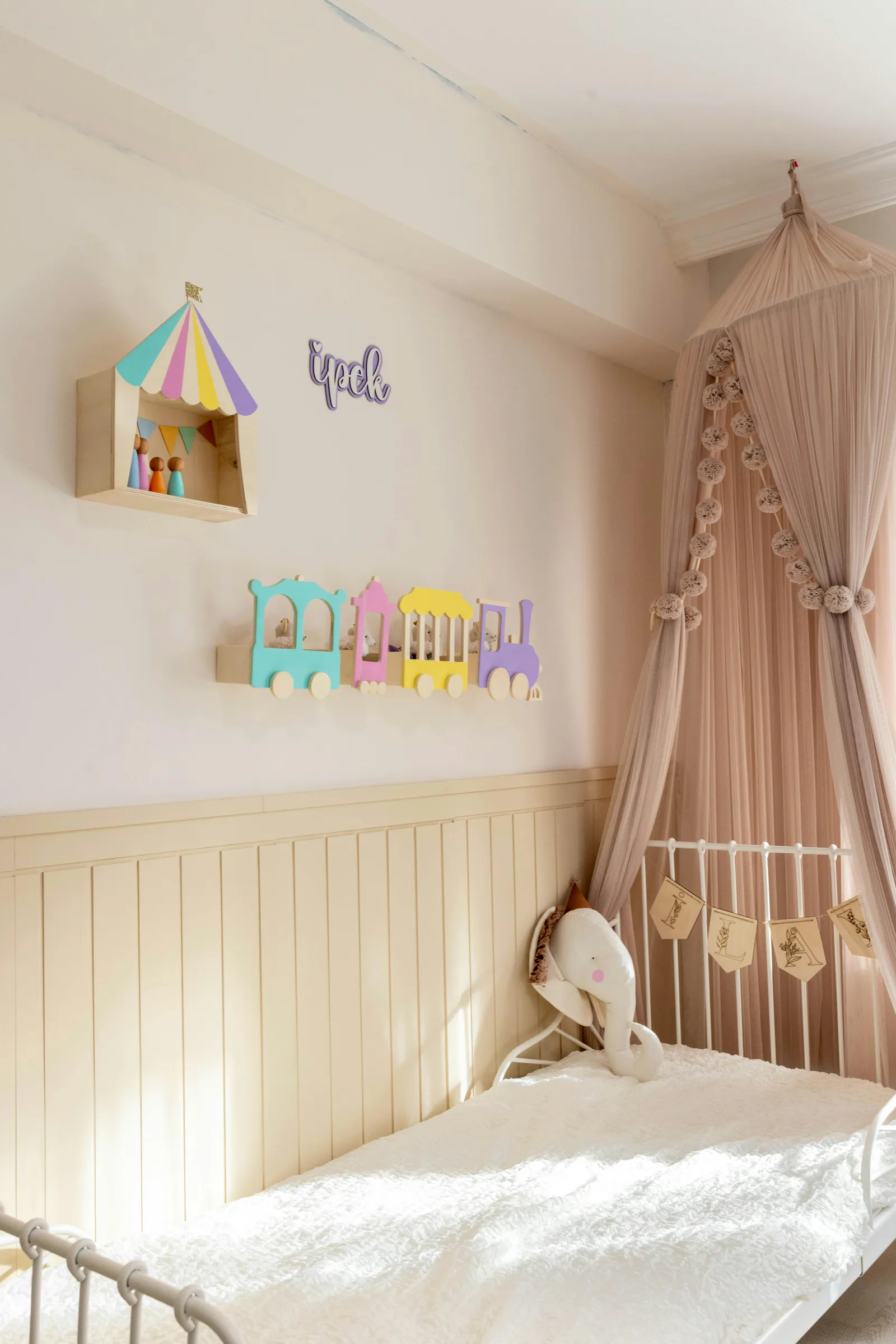 Chambre d'enfant au style pastel avec lit à baldaquin et décorations murales douces, atmosphère cosy et apaisante