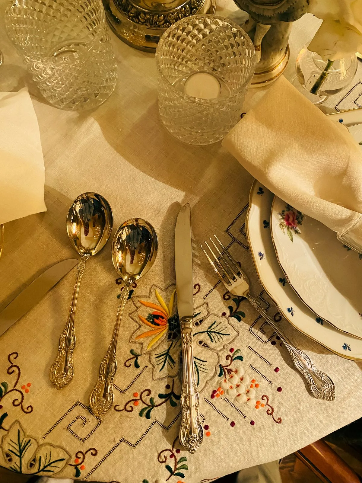 Chemin de table en lin brodé de motifs floraux avec couverts en argent pour une table de Noël élégante