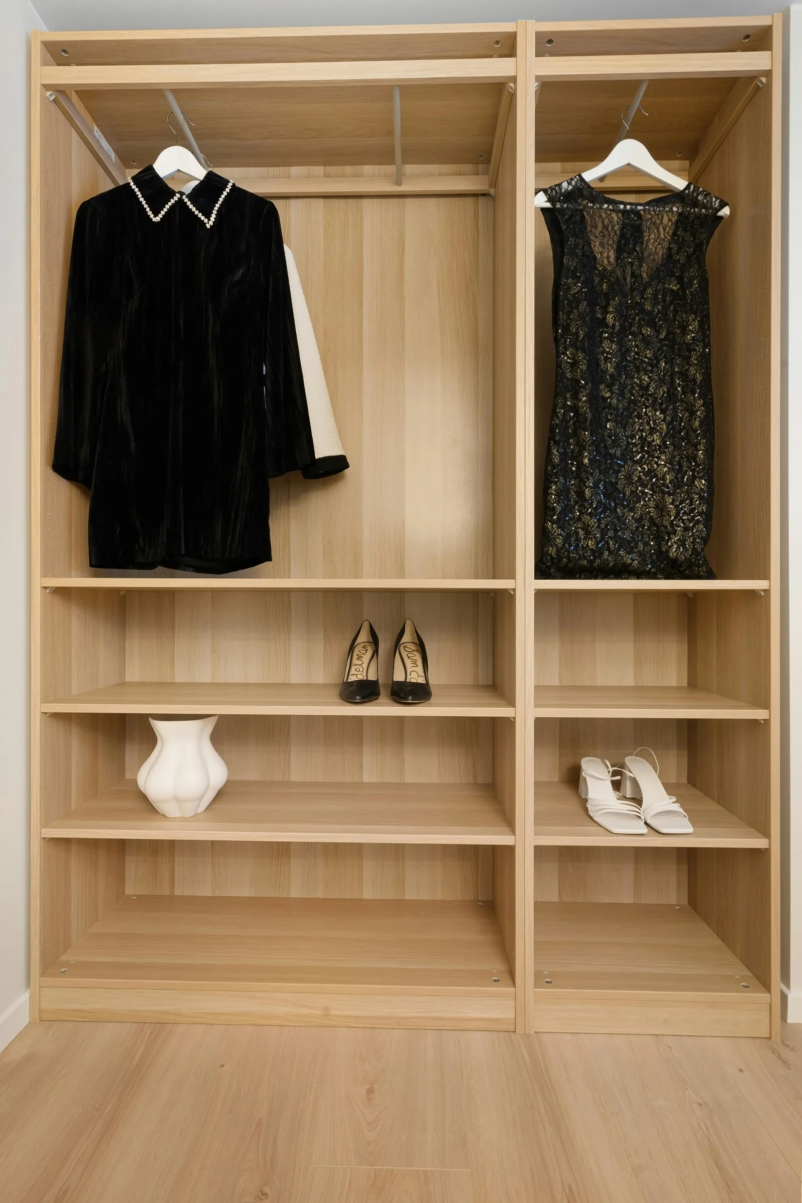 Dressing en bois clair avec robes élégantes et chaussures rangées — espace épuré