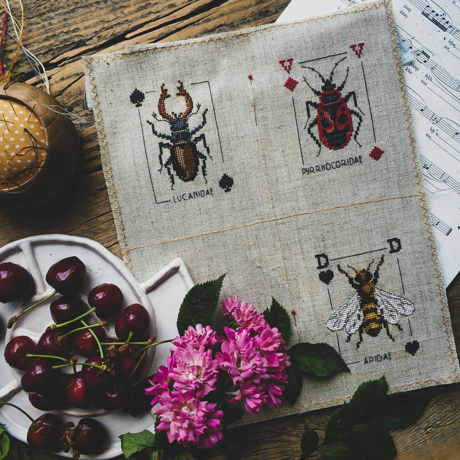 Grille point de croix avec motifs d'insectes brodés sur toile de lin naturel, illustration de la technique comptée