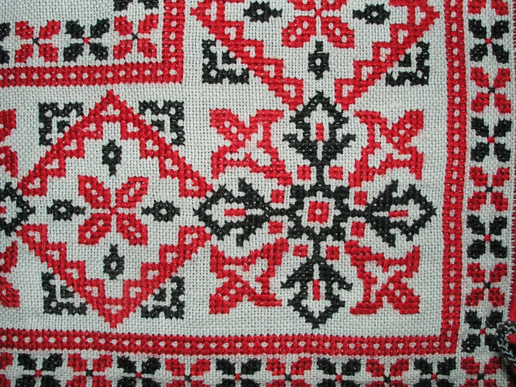 Point de croix en rouge et noir sur lin naturel blanc — motif géométrique traditionnel