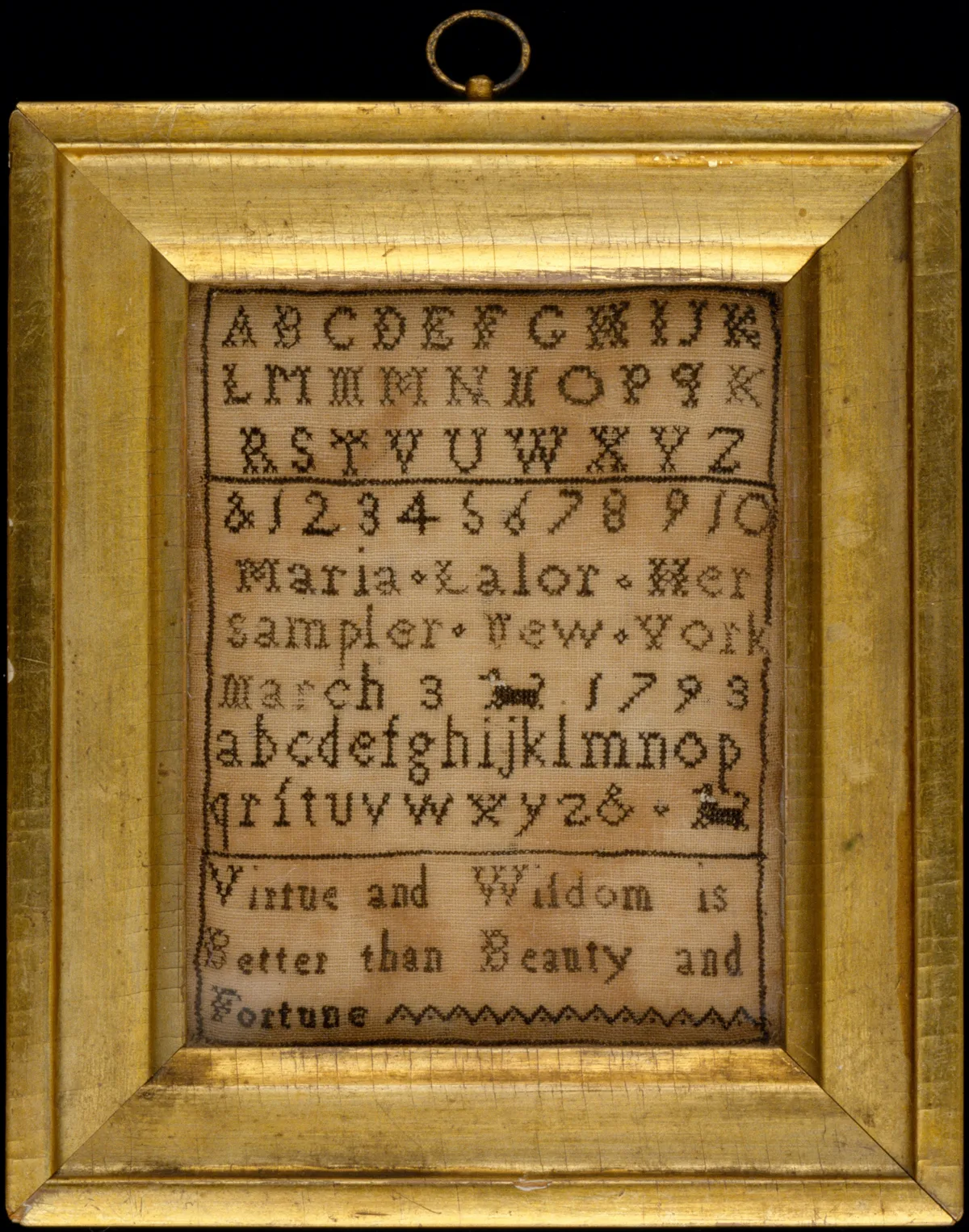 Sampler brodé encadré avec alphabet en point de croix — exemple de monogramme ancien dans un cadre doré