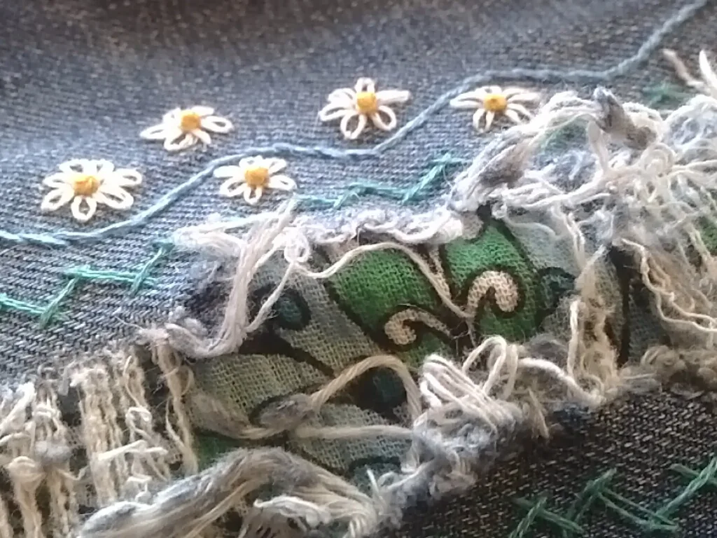 Broderie sur denim avec point de tige, marguerites en lazy daisy et points de remplissage