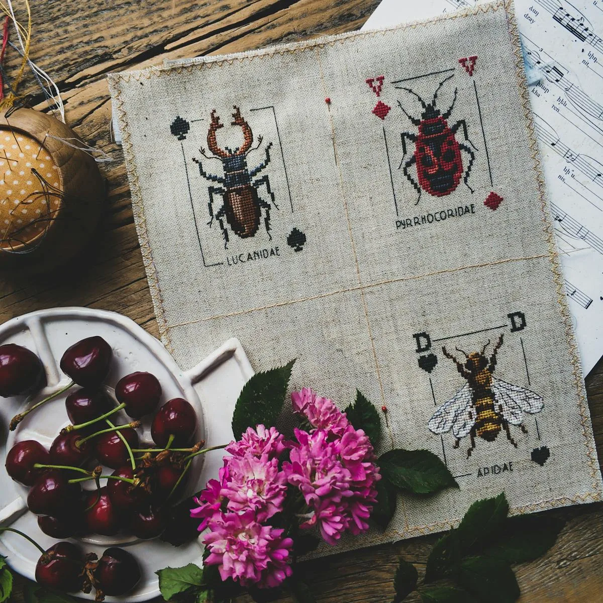 Broderie point de croix d'insectes et animaux sur lin — motifs naturalistes en style vintage