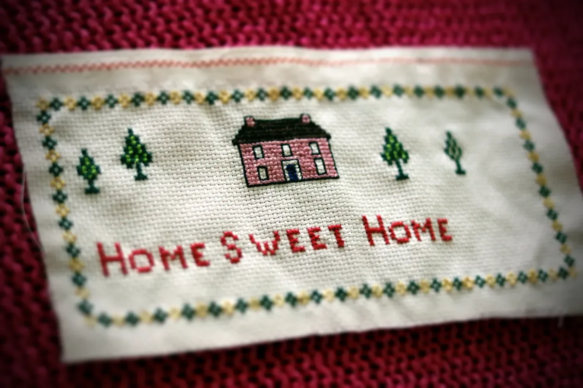 Tableau point de croix Home Sweet Home encadré et exposé, exemple de broderie finie mise en valeur